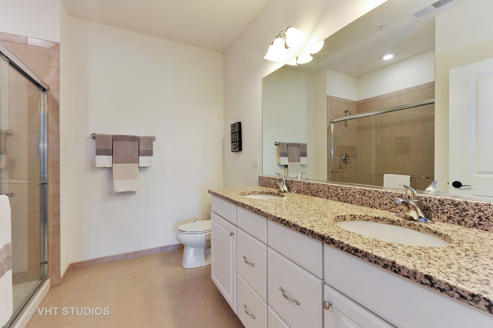2701 Commons Drive, Unit 207 Glenview, IL 60026 - Photo 12 of 23 a bathroom with a granite countertop sink a toilet and a mirror