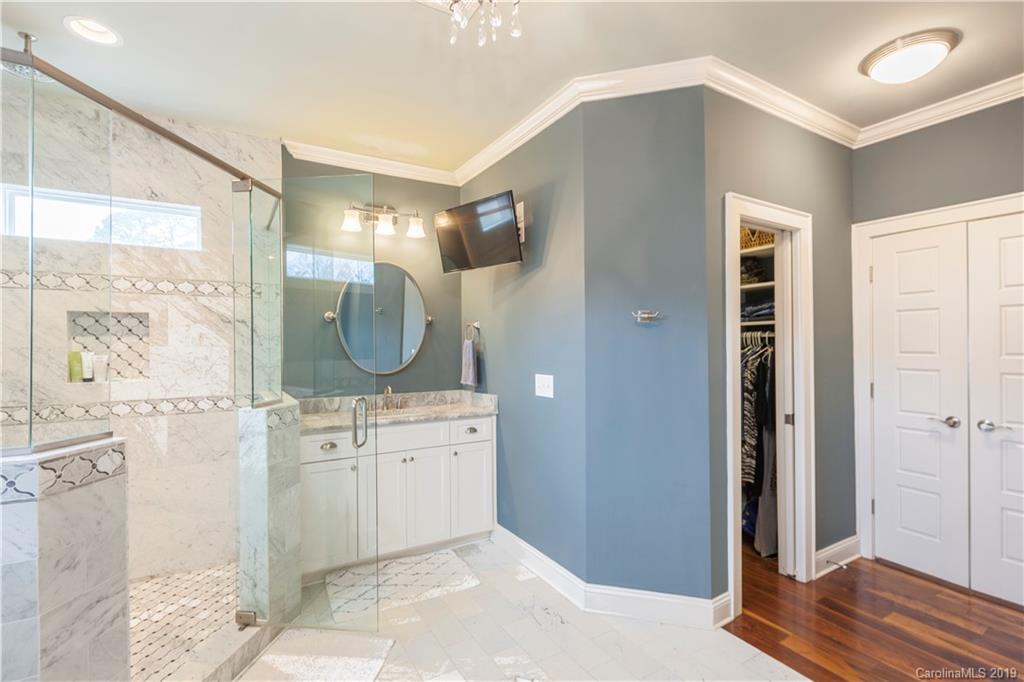 1911 Truman Road Charlotte, NC 28205 - Photo 18 of 30 a spacious bathroom with a mirror a sink and glass door