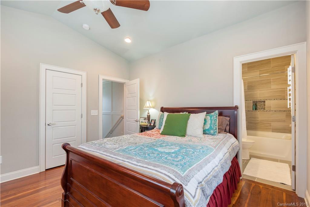 1911 Truman Road Charlotte, NC 28205 - Photo 22 of 30 a bedroom with a large bed and a chandelier