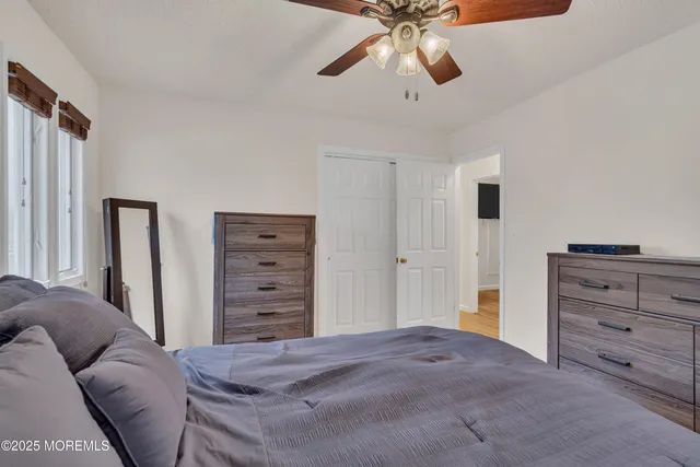 a bed room with a bed and a ceiling fan