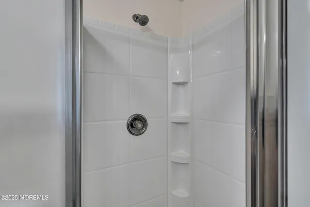 a bathroom with a shower and mirror
