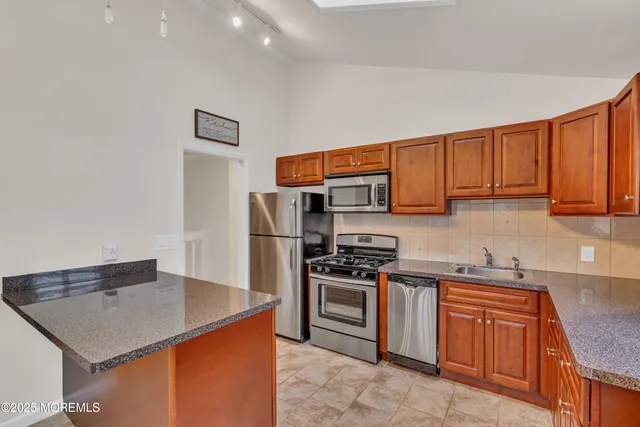 a kitchen with stainless steel appliances granite countertop a stove a sink dishwasher and a refrigerator