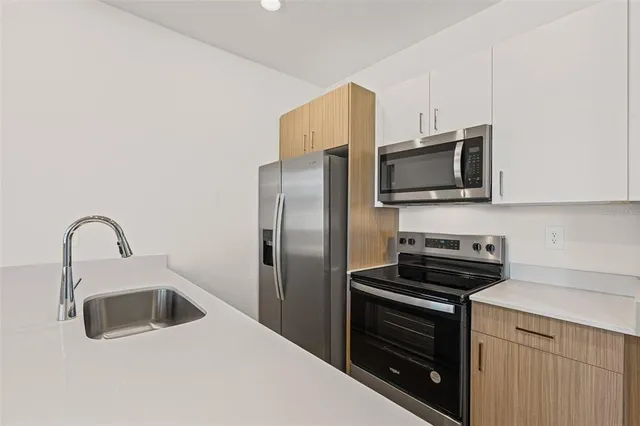 a kitchen with a sink and stainless steel appliances