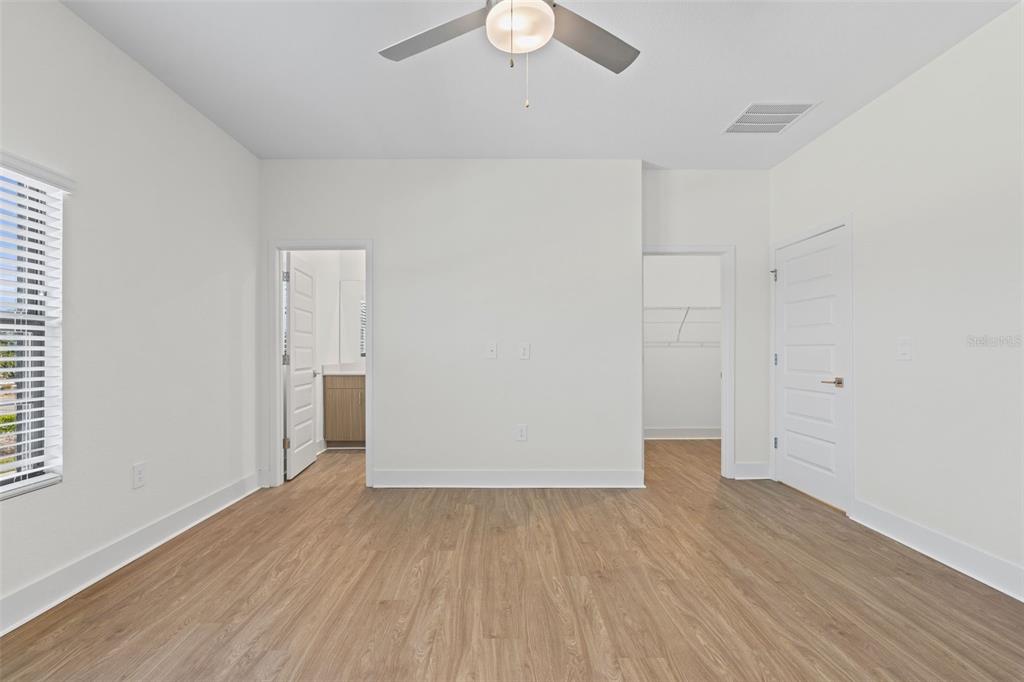 14456 Stellar Place Lakewood Ranch, FL 34202 - Photo 17 of 34 an empty room with wooden floor and windows