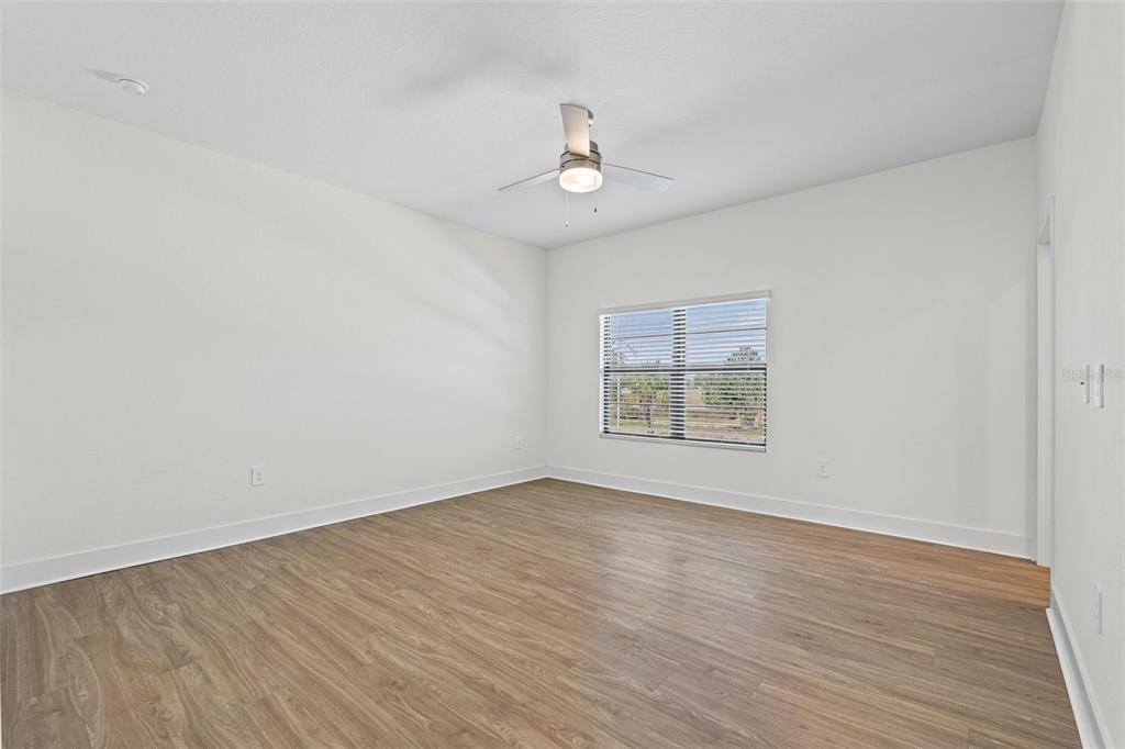 14456 Stellar Place Lakewood Ranch, FL 34202 - Photo 18 of 34 wooden floor in an empty room with a window