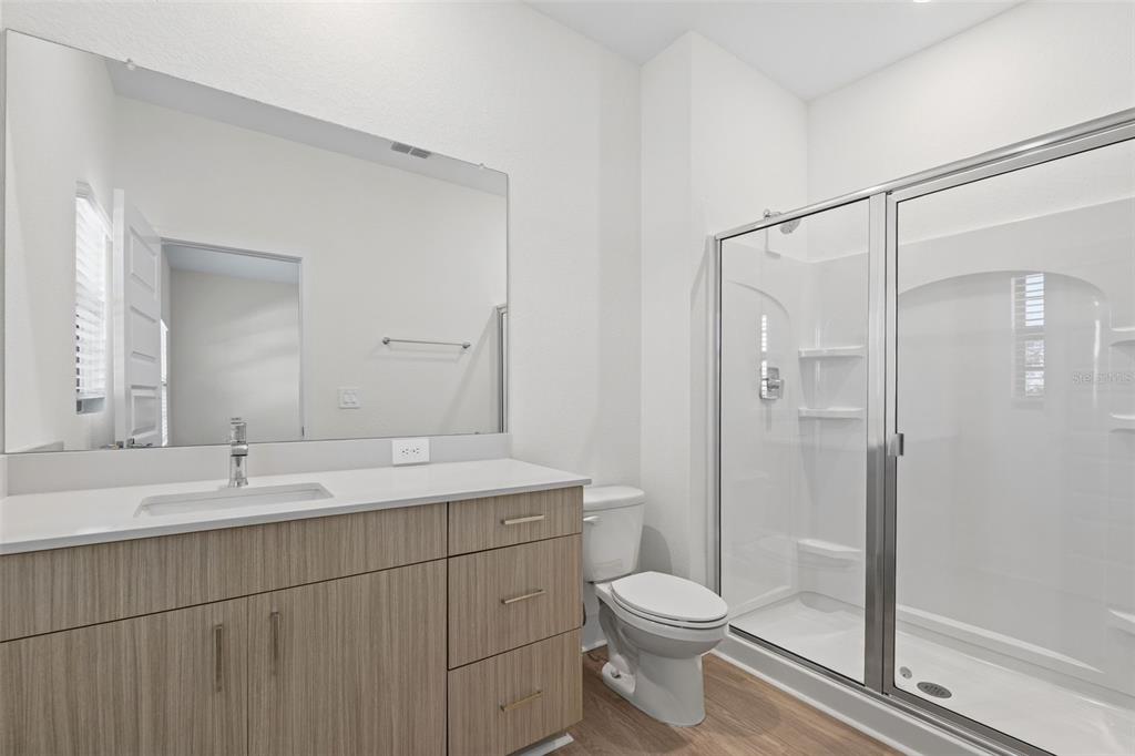 14456 Stellar Place Lakewood Ranch, FL 34202 - Photo 19 of 34 a bathroom with a double vanity sink toilet and shower