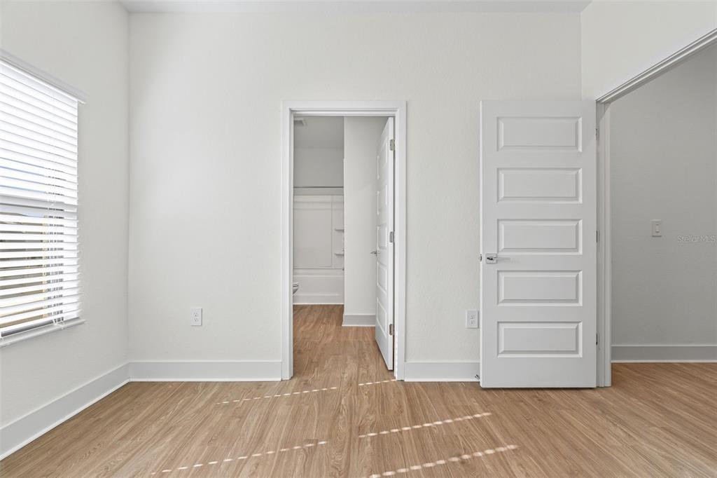 14456 Stellar Place Lakewood Ranch, FL 34202 - Photo 23 of 34 an empty room with wooden floor closet and windows