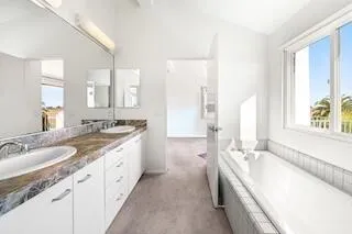 a spacious bathroom with sinks vanity granite tub shower and a mirror
