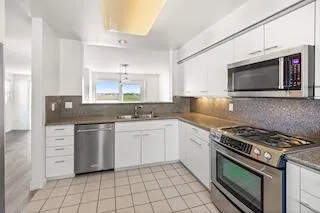 a kitchen with cabinets appliances and a window