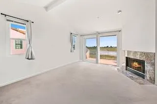 a view of an empty room with a fireplace and a window