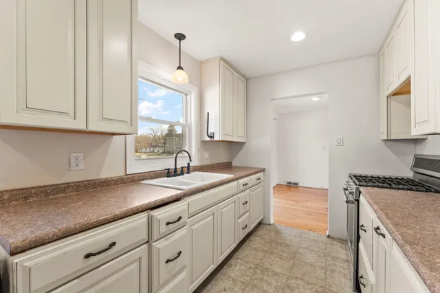 a kitchen with granite countertop a sink a stove and cabinets