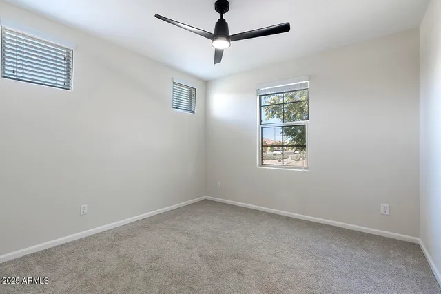 an empty room with a window and a fan