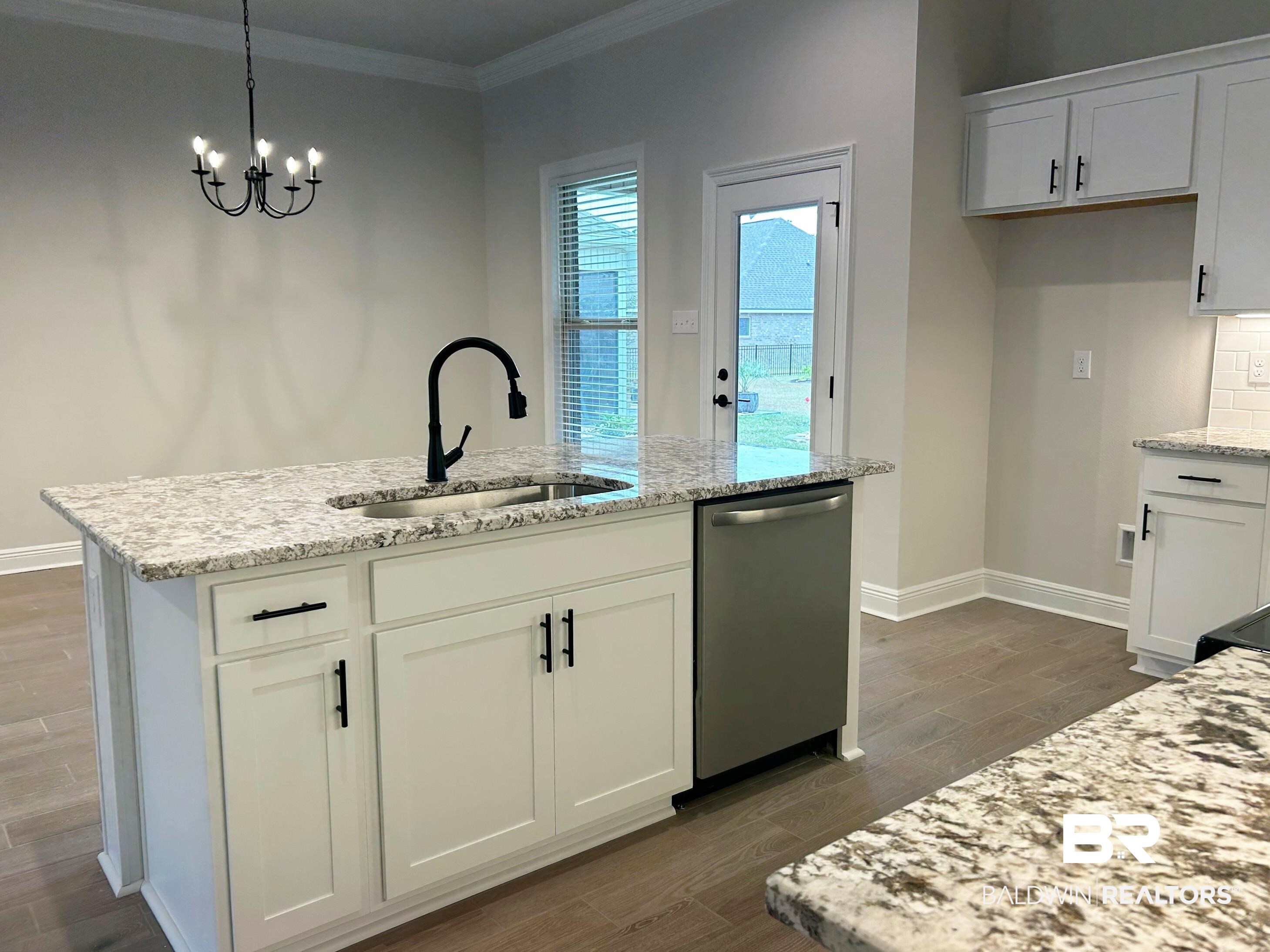 873 Sumter Loop Foley, AL 36535 - Photo 9 of 26 Kitchen with white cabinets, light stone counters, stainless steel dishwasher, pendant lighting, and wood tiled floors