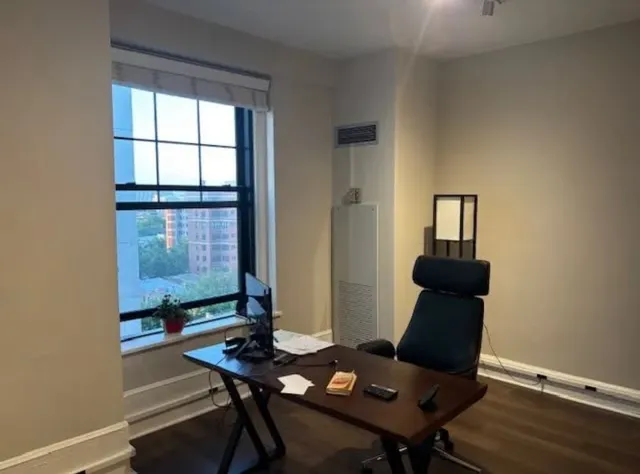 a view of a workspace with furniture and window