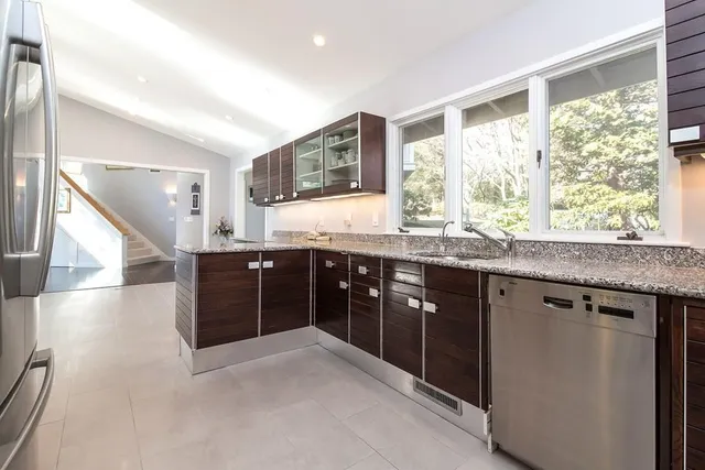 a kitchen with stainless steel appliances granite countertop a sink and a large window