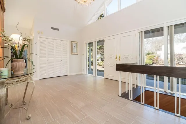 a view of an empty room with wooden floor and furniture