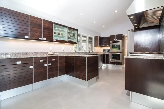 a kitchen with stainless steel appliances granite countertop a stove a sink and a refrigerator