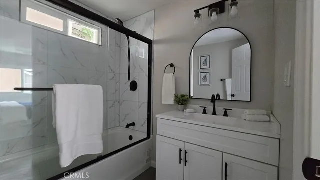 a bathroom with a sink a mirror and shower