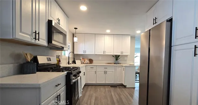 a kitchen with a sink a stove top oven and cabinets