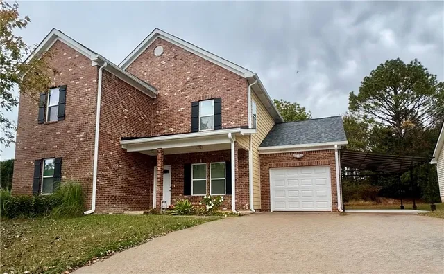 a front view of a house with a garden