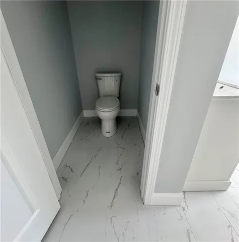 a white toilet sitting next to a shower