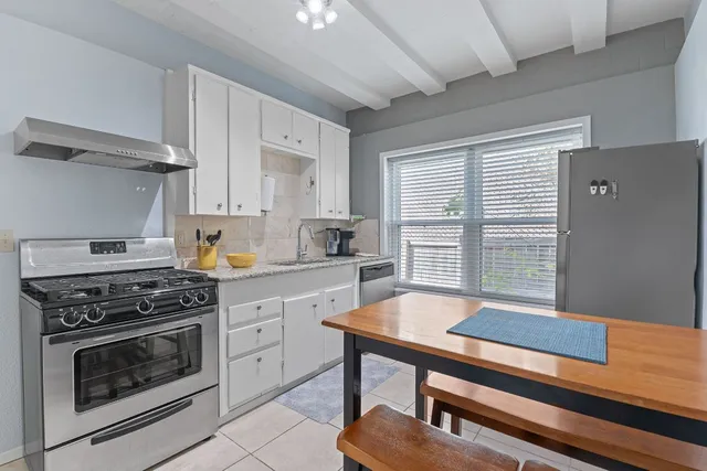 a kitchen with white cabinets and appliances