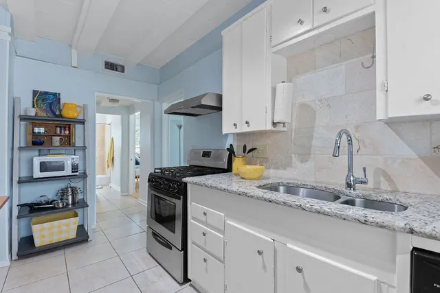 a kitchen with granite countertop a refrigerator and a sink