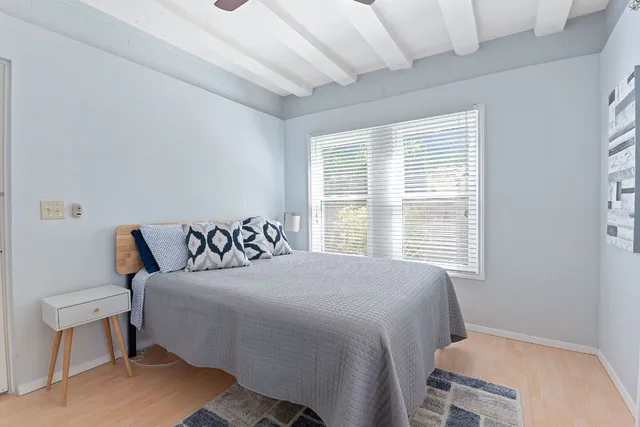 a bedroom with a bed a mirror and a window