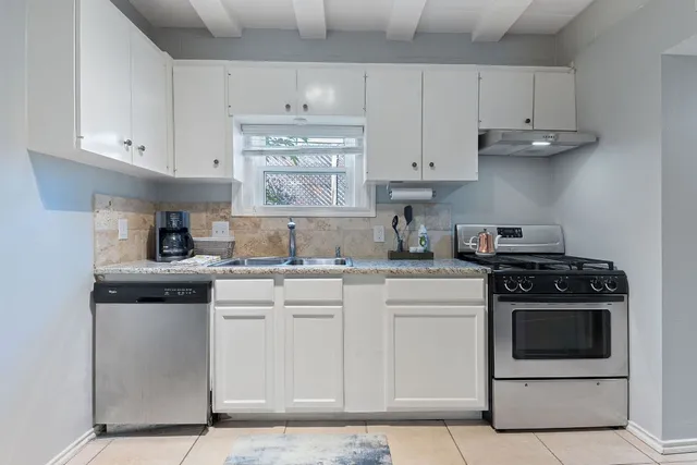 a kitchen with cabinets appliances and a sink