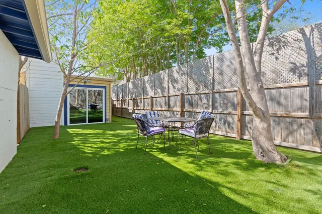 a view of a backyard with a small cabin and wooden fence