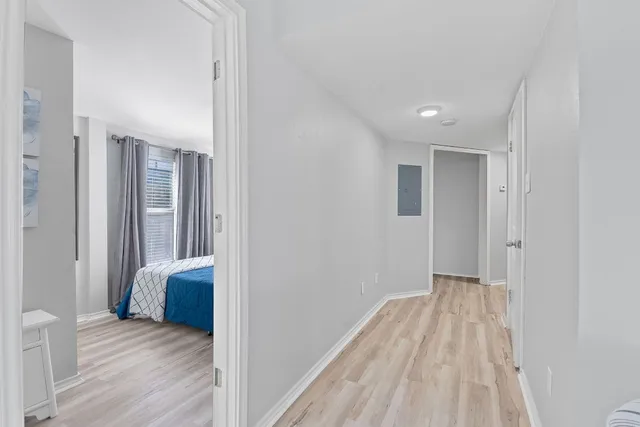 a view of a bedroom with wooden floor and a bathroom