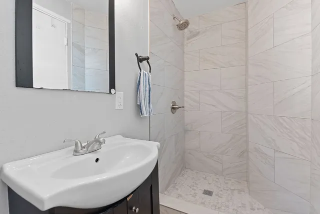 a bathroom with a sink a shower and a mirror