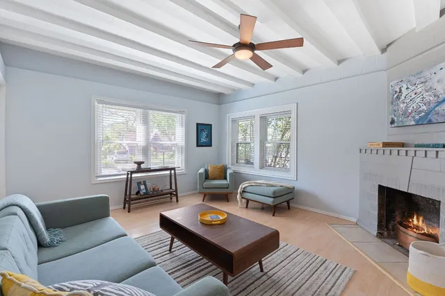 a living room with furniture a fireplace and a window