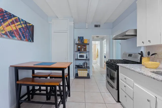 a kitchen with stainless steel appliances granite countertop a stove refrigerator and a microwave