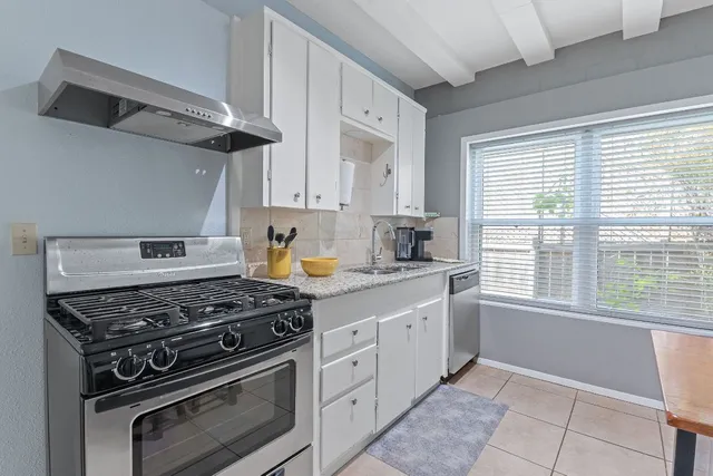 a kitchen with cabinets appliances and a window