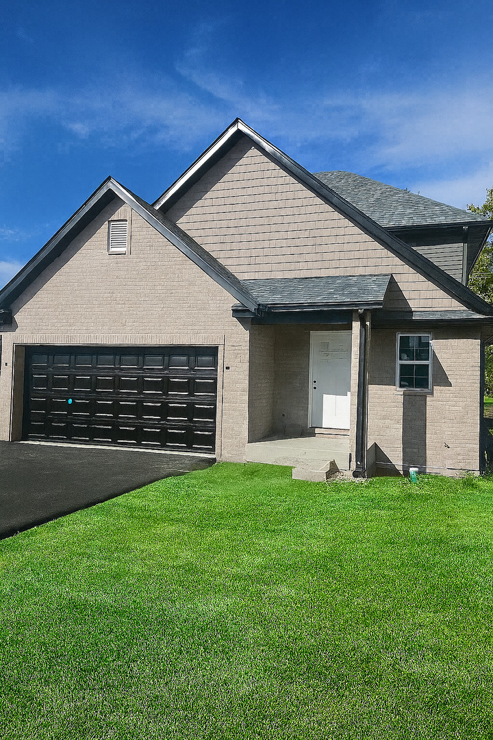 740 East 155th Street Phoenix, IL 60426 - Photo 1 of 18 a front view of a house with a yard and garage
