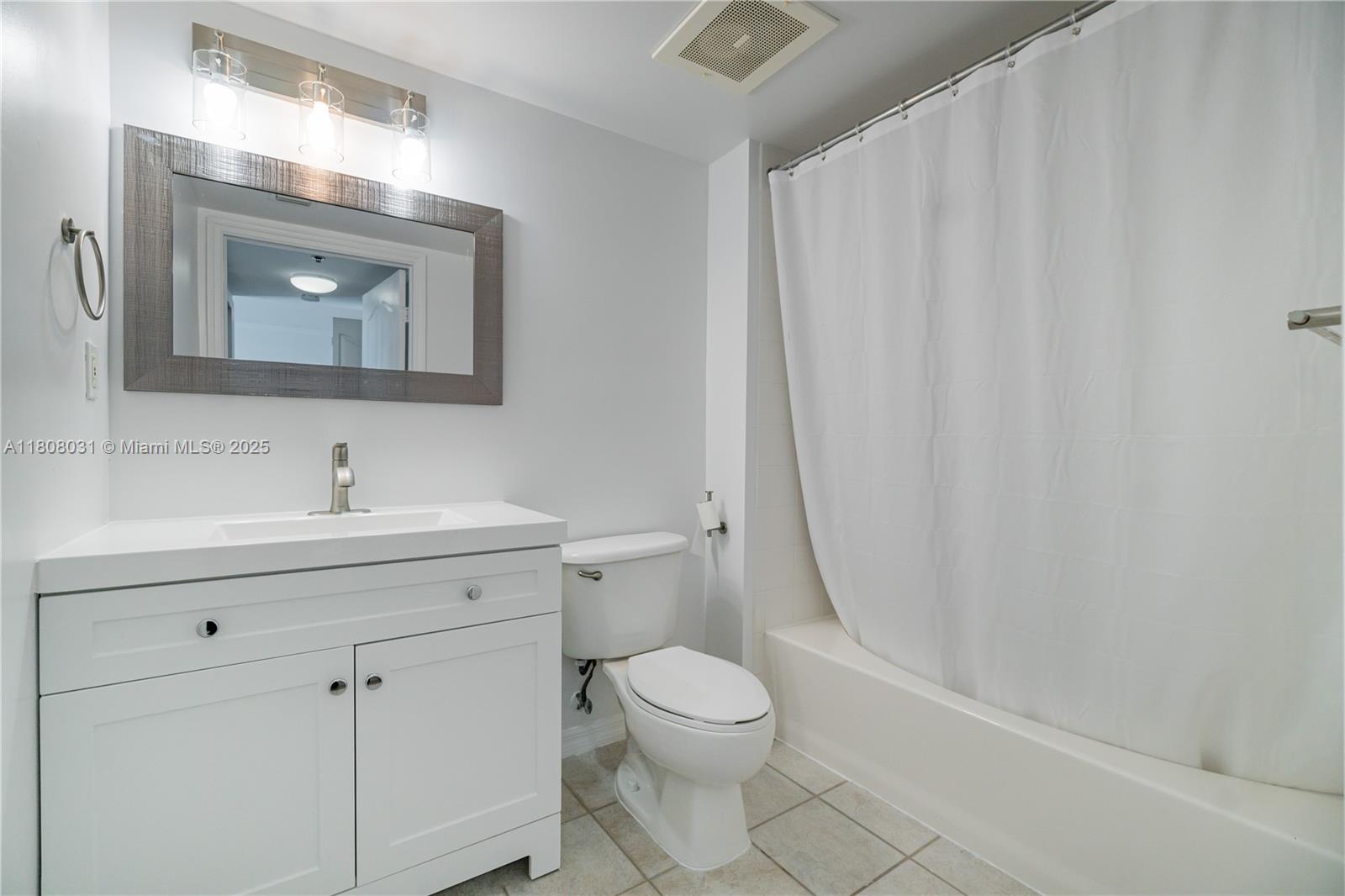 2665 Southwest 37th Avenue, Unit 906 Miami, FL 33133 - Photo 17 of 35 a bathroom with a toilet a sink a mirror and a shower