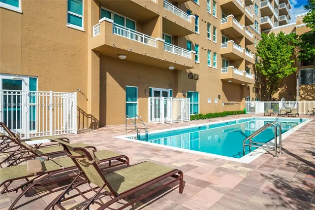 a view of a house with pool and chairs