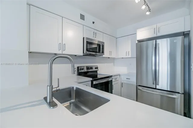 a kitchen with stainless steel appliances a refrigerator sink and microwave