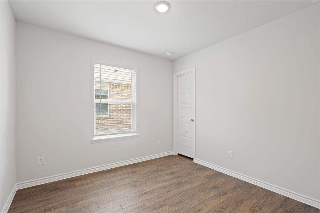 1600 Romans Road Ennis, TX 75119 - Photo 13 of 19 an empty room with wooden floor and windows