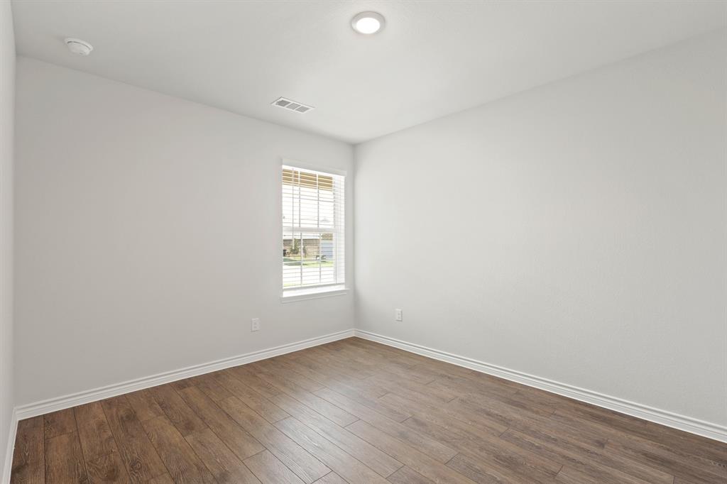 1600 Romans Road Ennis, TX 75119 - Photo 16 of 19 an empty room with wooden floor and windows