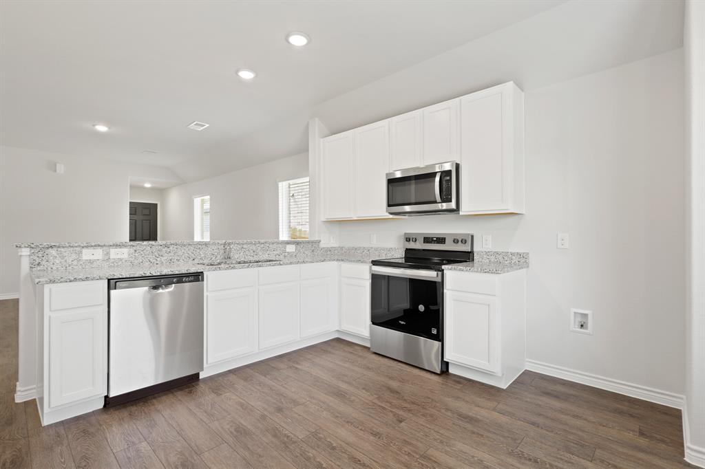 1600 Romans Road Ennis, TX 75119 - Photo 5 of 19 a kitchen with granite countertop a stove top oven a sink dishwasher and a microwave with wooden floor