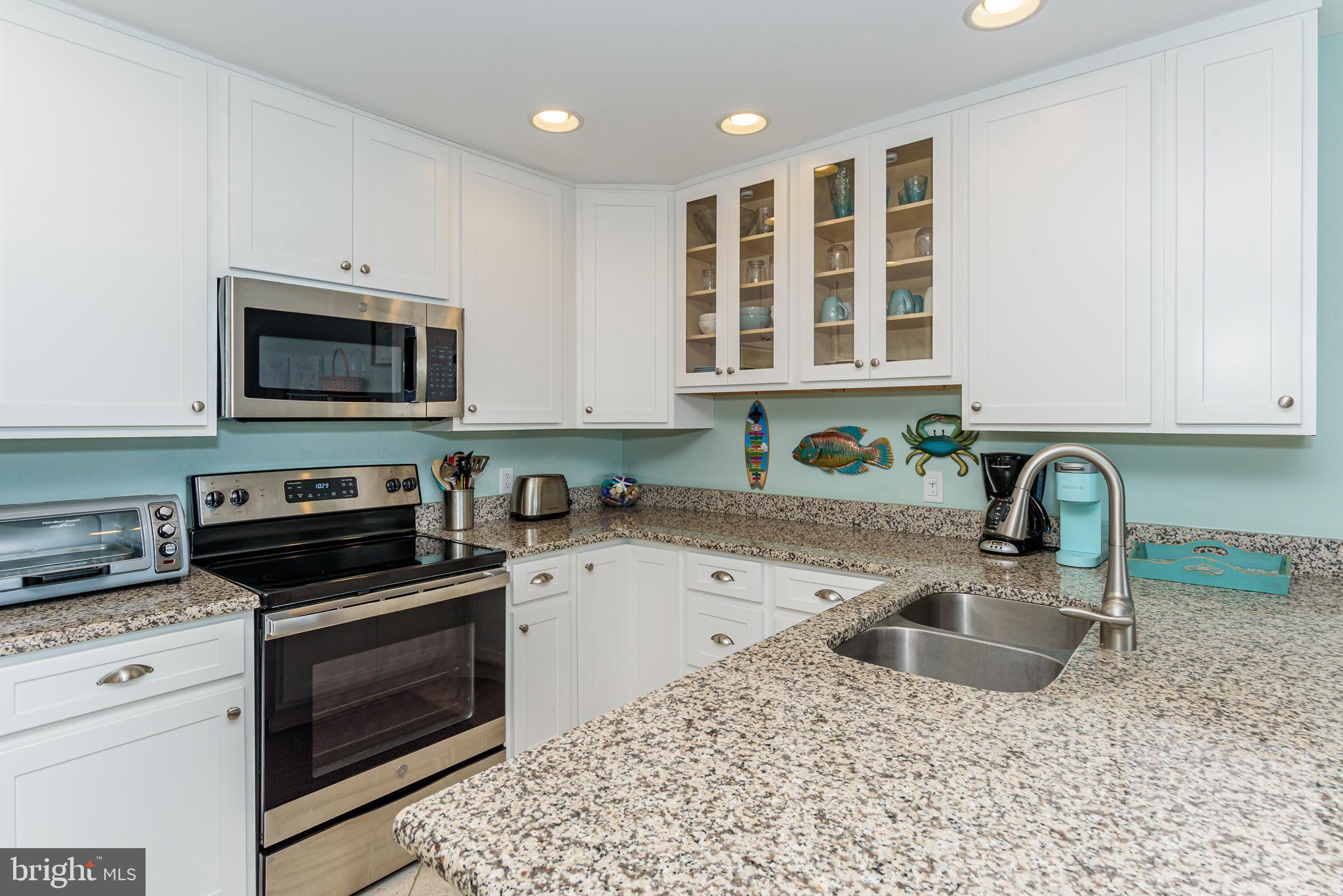 7601 Atlantic Avenue, Unit 3 Ocean City, MD 21842 - Photo 37 of 52 a kitchen with stainless steel appliances granite countertop a sink stove and cabinets