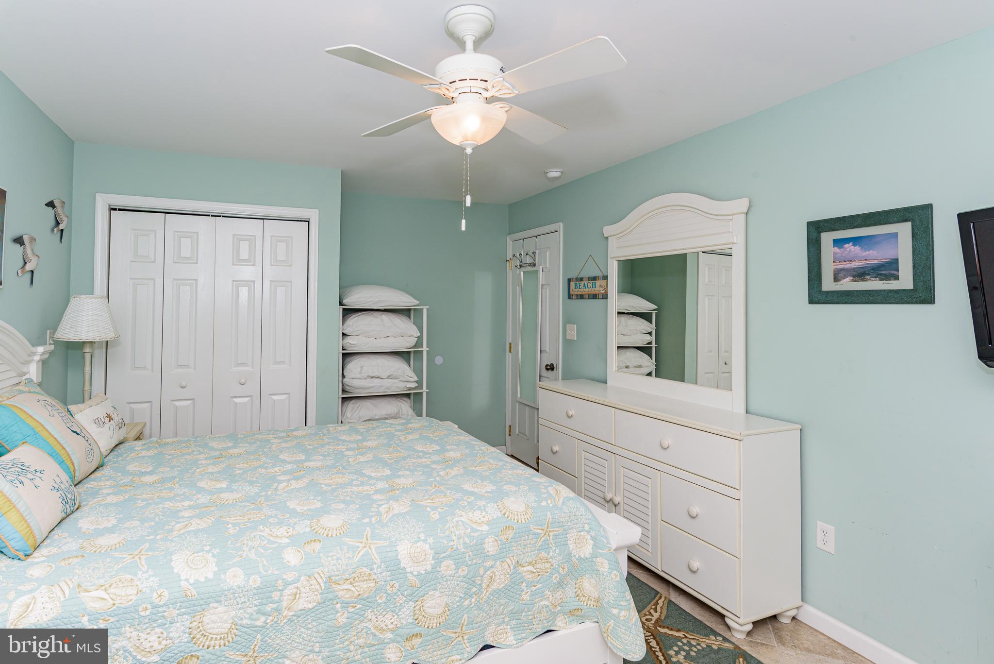 7601 Atlantic Avenue, Unit 3 Ocean City, MD 21842 - Photo 43 of 52 a bedroom with a large bed and a chandelier