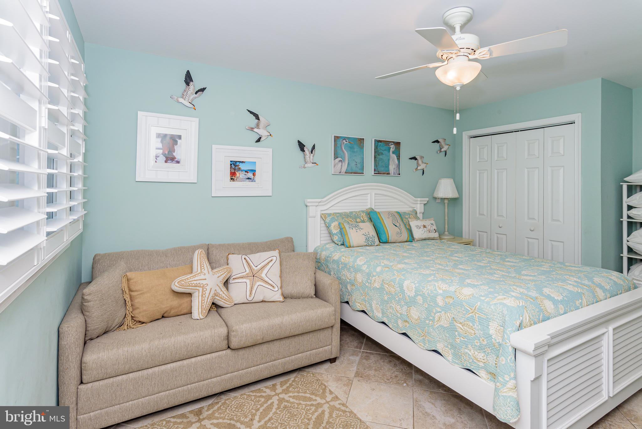 7601 Atlantic Avenue, Unit 3 Ocean City, MD 21842 - Photo 45 of 52 a bedroom with a bed couch and a window