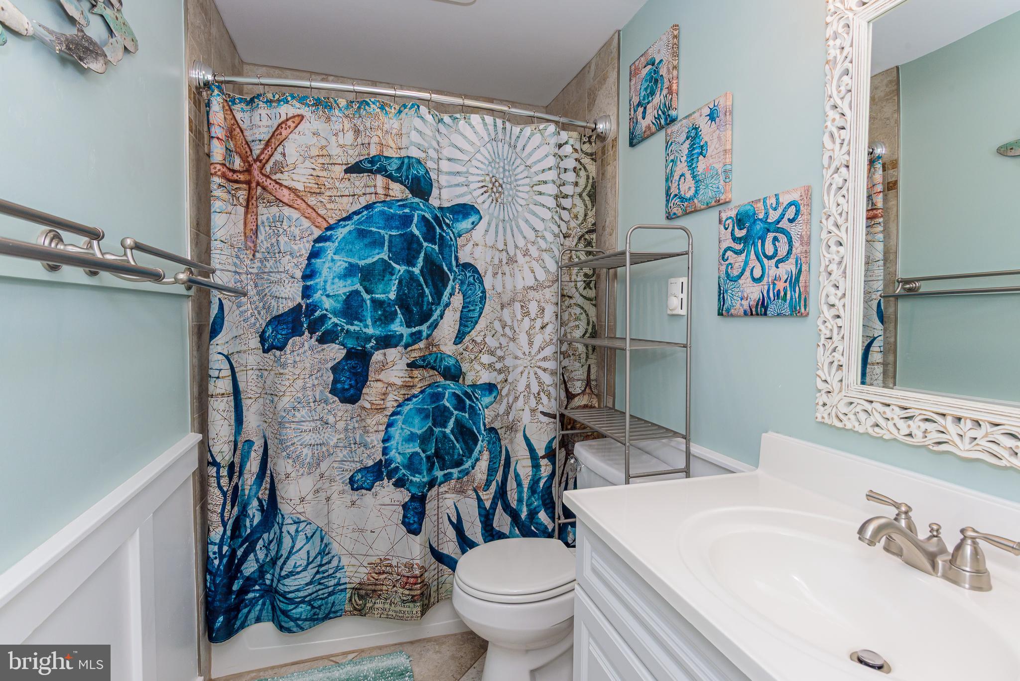 7601 Atlantic Avenue, Unit 3 Ocean City, MD 21842 - Photo 49 of 52 a bathroom with a sink a toilet and a shower curtain