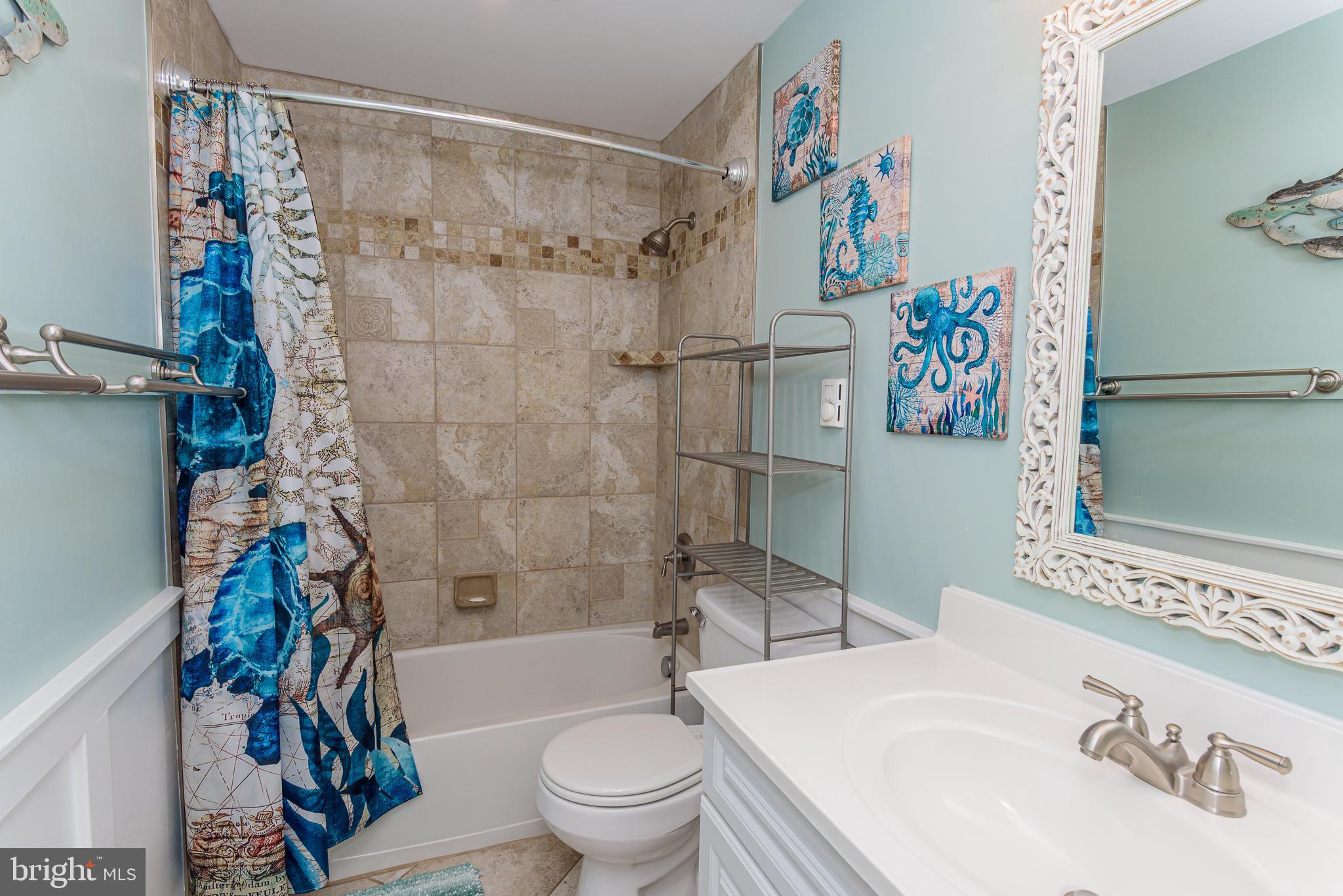 7601 Atlantic Avenue, Unit 3 Ocean City, MD 21842 - Photo 50 of 52 a bathroom with a toilet a sink and a shower curtain