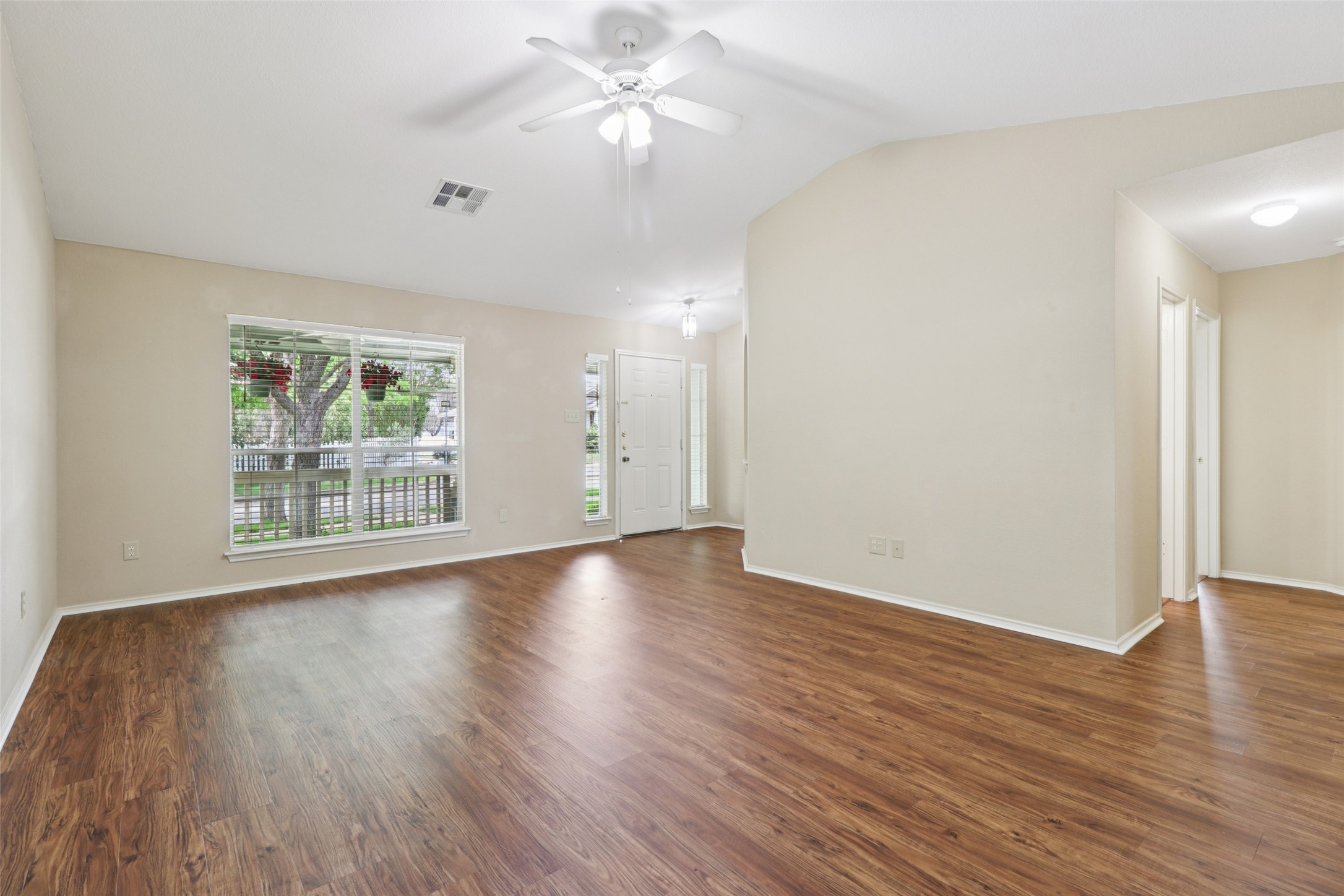 700 Scheel Road Kyle, TX 78640 - Photo 8 of 39 Spacious living area featuring durable wood-look flooring, light-colored walls, and a ceiling fan