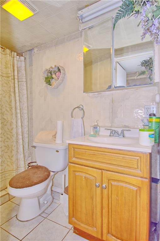 8800 19th Avenue Brooklyn, NY 11214 - Photo 18 of 26 a bathroom with a toilet a sink and a mirror