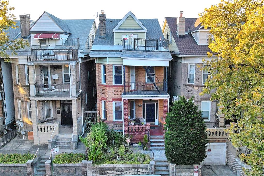 8800 19th Avenue Brooklyn, NY 11214 - Photo 21 of 26 a front view of a residential apartment building with a yard and potted plants